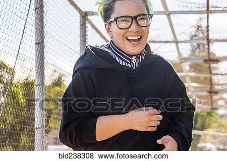 Stock Photo - Androgynous Asian woman laughing on footbridge. Fotosearch