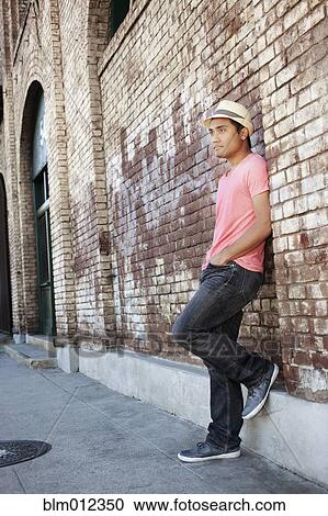 Asian man leaning against brick wall View Large Photo Image Stock Image - Asian man leaning against brick wall. Fotosearch