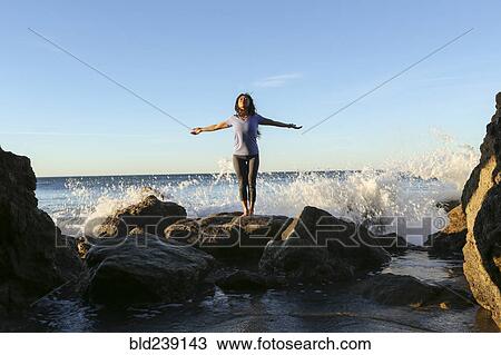 Asian woman standing on rock at beach View Large Photo Image Stock Image - Asian woman standing on rock at beach. Fotosearch