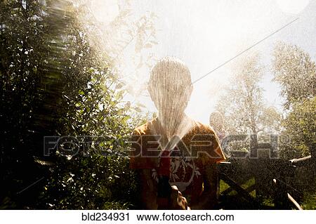Back lit Mari boy spraying hose at face View Large Photo Image Stock Image - Back lit Mari boy spraying hose at face. Fotosearch