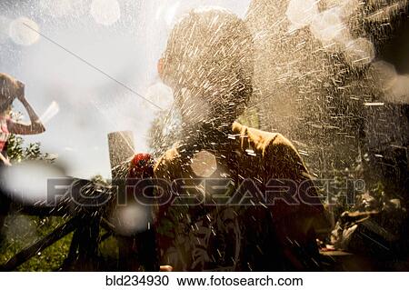 Back lit Mari boy spraying hose View Large Photo Image Stock Image - Back lit Mari boy spraying hose. Fotosearch