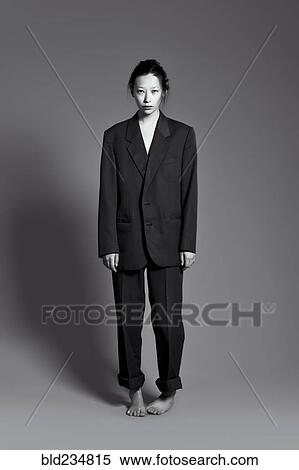 Barefoot Asian woman wearing large suit View Large Photo Image Stock Photography - Barefoot Asian woman wearing large suit. Fotosearch