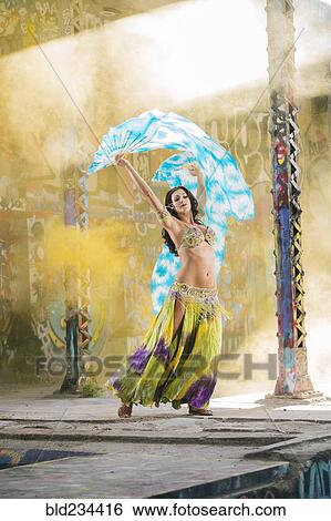Belly dancer holding blue and white fabric View Large Photo Image Stock Photograph - Belly dancer holding blue and white fabric. Fotosearch