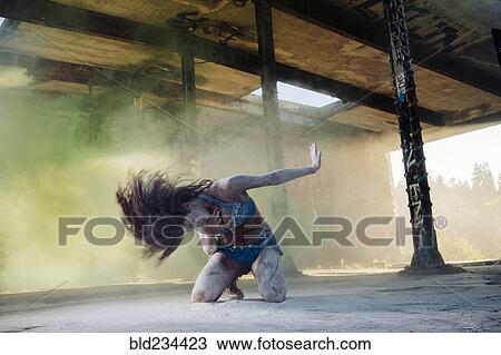 Stock Image - Belly dancer kneeling in powder. Fotosearch