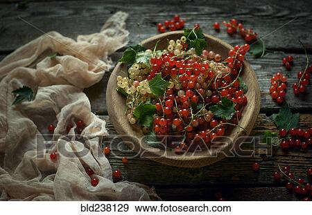 Stock Photo - Berries in bowl on wooden table. Fotosearch