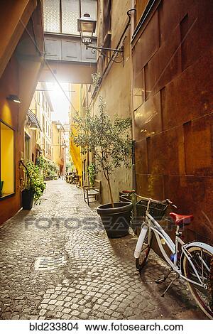 Picture - "Bicycle in cobblestone alley, Bologna, Emilia-Romagna, Italy". Fotosearch