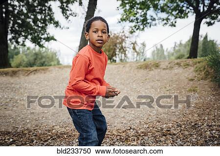 Stock Image - Black boy holding stone. Fotosearch