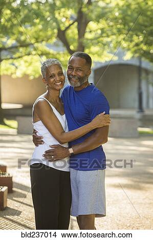 Picture - Black couple hugging in park. Fotosearch
