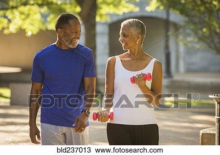 Black couple walking in park View Large Photo Image Stock Image - Black couple walking in park. Fotosearch