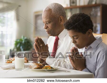 Black grandson and grandfather praying before meal View Large Photo Image Stock Image - Black grandson and grandfather praying before meal. Fotosearch