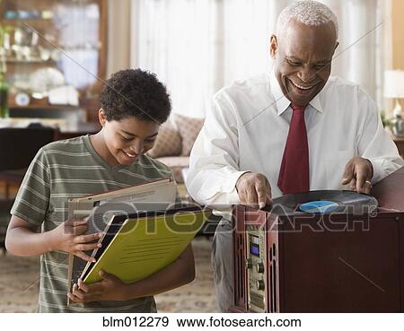 Black grandson and grandfather listening to record player View Large Photo Image Stock Photo - Black grandson and grandfather listening to record player. Fotosearch
