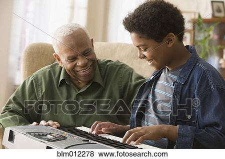 Black grandson playing keyboard for grandfather View Large Photo Image Stock Photo - Black grandson playing keyboard for grandfather. Fotosearch