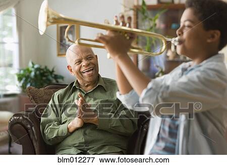 Black grandson playing trumpet for grandfather View Large Photo Image Stock Photo - Black grandson playing trumpet for grandfather. Fotosearch