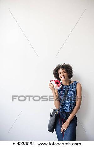 Black woman carrying purse holding headphones View Large Photo Image Picture - Black woman carrying purse holding headphones. Fotosearch