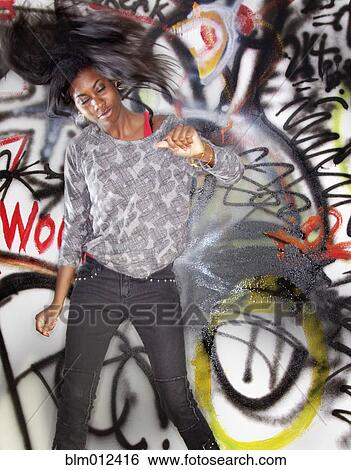 Black woman dancing near graffitied wall View Large Photo Image Stock Photograph - Black woman dancing near graffitied wall. Fotosearch