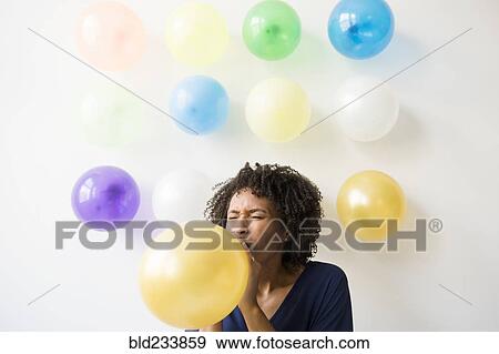 Black woman inflating balloon View Large Photo Image Stock Photo - Black woman inflating balloon. Fotosearch