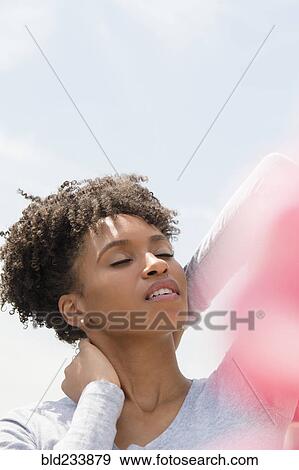 Black woman rubbing neck outdoors View Large Photo Image Stock Photo - Black woman rubbing neck outdoors. Fotosearch