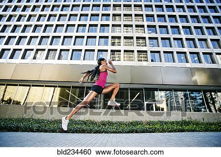 Black woman running and jumping on city sidewalk View Large Photo Image Stock Image - Black woman running and jumping on city sidewalk. Fotosearch
