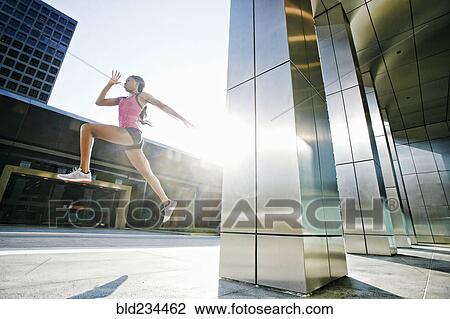 Black woman running and jumping on city sidewalk View Large Photo Image Stock Image - Black woman running and jumping on city sidewalk. Fotosearch