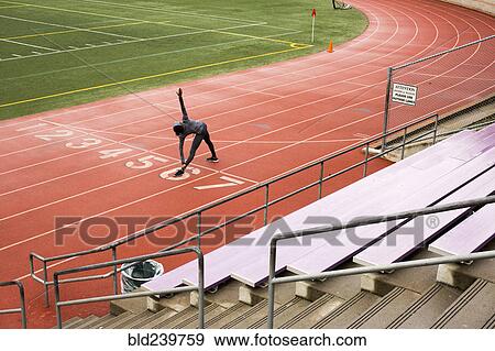 Stock Photo - Black woman stretching on track. Fotosearch