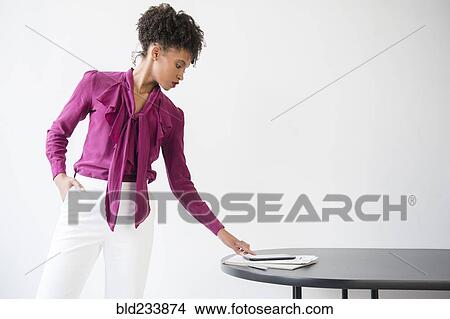 Black woman wearing purple blouse checking digital tablet View Large Photo Image Picture - Black woman wearing purple blouse checking digital tablet. Fotosearch