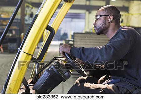 Black worker driving forklift in factory View Large Photo Image Stock Image - Black worker driving forklift in factory. Fotosearch