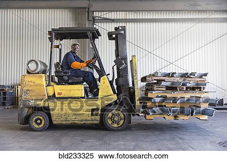 Stock Photography - Black worker driving forklift in factory. Fotosearch