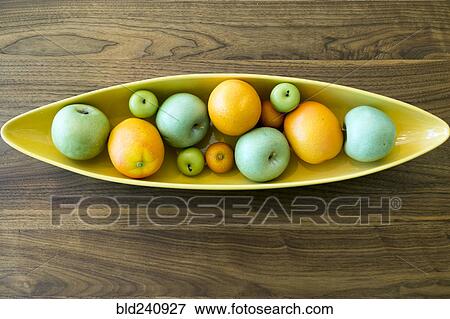 Stock Photo - Bowl with fruit on wooden table. Fotosearch