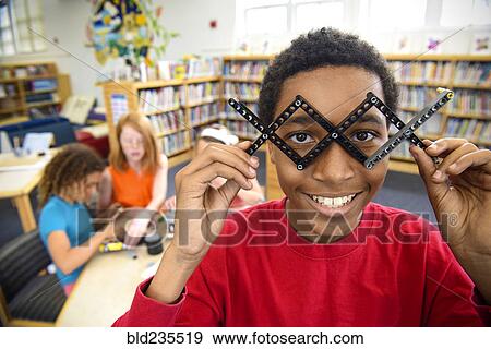 Boy playing with plastic blocks in library View Large Photo Image Stock Photo - Boy playing with plastic blocks in library. Fotosearch