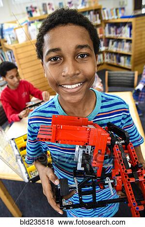 Stock Photo - Boy posing with plastic blocks in library. Fotosearch