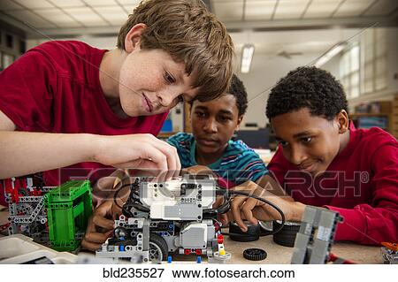 Stock Photo - Boys assembling plastic blocks in library. Fotosearch