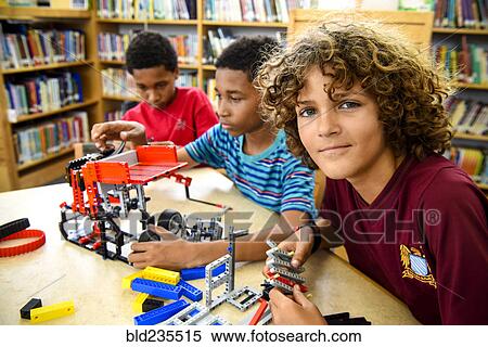 Stock Photography - Boys assembling plastic blocks in library. Fotosearch