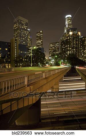 Stock Image - Bridge over lights on urban highway at night. Fotosearch
