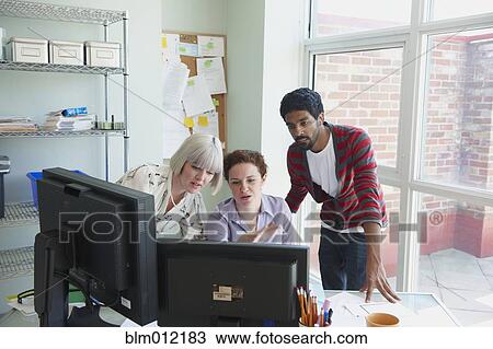 Stock Image - Business people looking at computer. Fotosearch