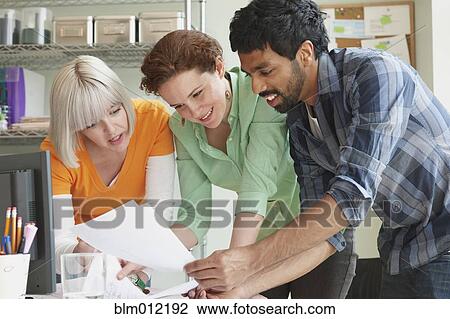 Stock Image - Business people working together in office. Fotosearch