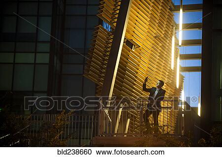 Businessman on balcony posing for cell phone selfie at night View Large Photo Image Stock Image - Businessman on balcony posing for cell phone selfie at night. Fotosearch