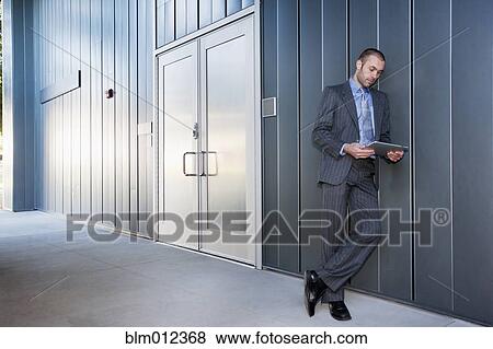 Stock Photo - Businessman using digital tablet outdoors. Fotosearch