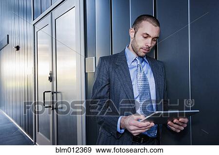 Stock Photo - Businessman using digital tablet outdoors. Fotosearch