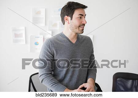 Stock Photo - Businessman wearing sweater in office. Fotosearch