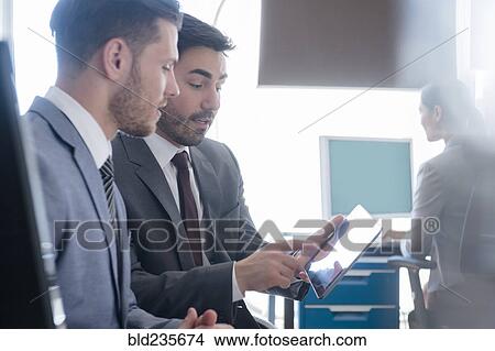 Businessmen using digital tablet in office View Large Photo Image Picture - Businessmen using digital tablet in office. Fotosearch
