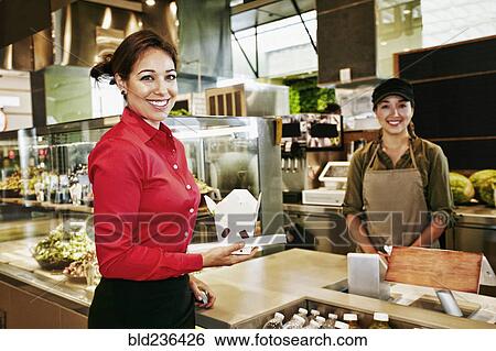 Businesswoman holding carton of food in food court View Large Photo Image Stock Photograph - Businesswoman holding carton of food in food court. Fotosearch