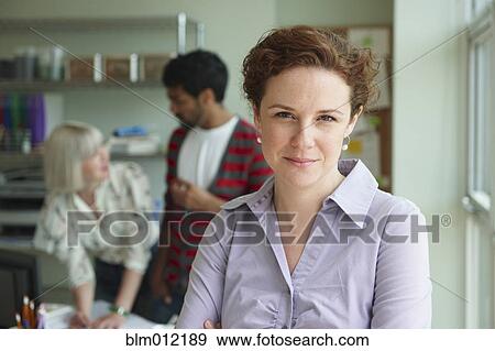 Businesswoman in office with co-workers View Large Photo Image Stock Photo - Businesswoman in office with co-workers. Fotosearch