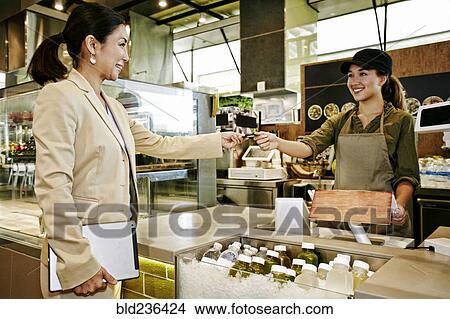 Businesswoman paying cashier in food court with credit card View Large Photo Image Picture - Businesswoman paying cashier in food court with credit card. Fotosearch