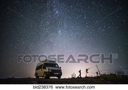Stock Photograph - Camper van under starry sky. Fotosearch
