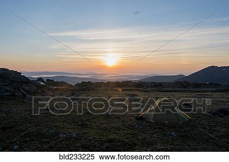 Stock Photography - Camping tent in barren field at sunset. Fotosearch