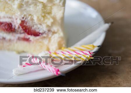 Stock Photo - Candles on plate with slice of birthday cake. Fotosearch
