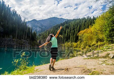 Stock Image - Carefree Caucasian woman walking near lake . Fotosearch