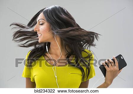 Carefree Indian woman tossing hair and listening to music View Large Photo Image Stock Image - Carefree Indian woman tossing hair and listening to music. Fotosearch