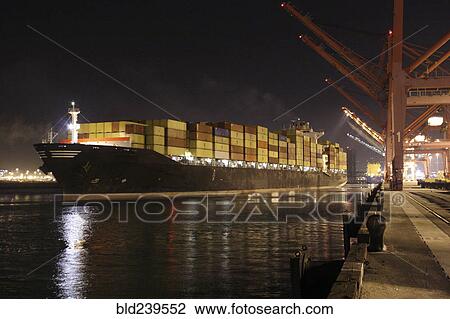 Stock Image - Cargo containers on freighter in port. Fotosearch