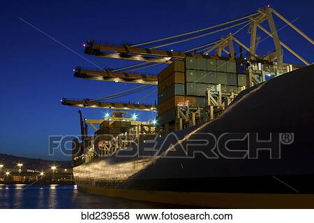Stock Photo - Cargo containers on freighter in port at night. Fotosearch